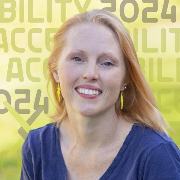 Headshot of Ashley outdoors with the sun shining brightly on the lawn in the background