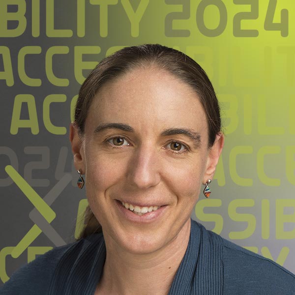 Headshot of Carmody in a blue blazer smiling against a grey background